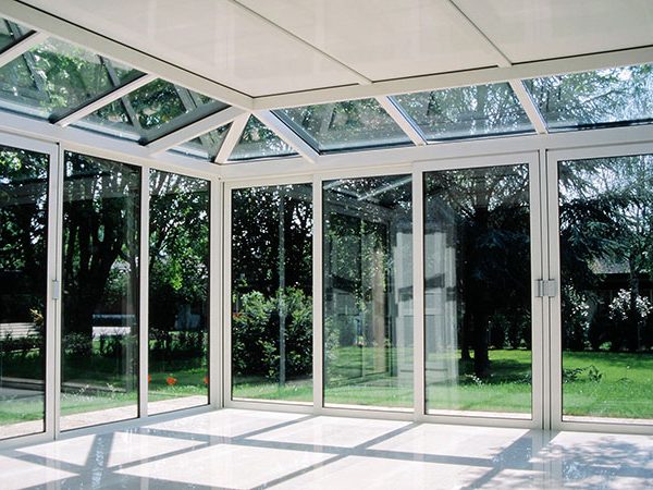 Grande véranda blanche avec vue sur le jardin Grande véranda blanche avec vue sur le jardin